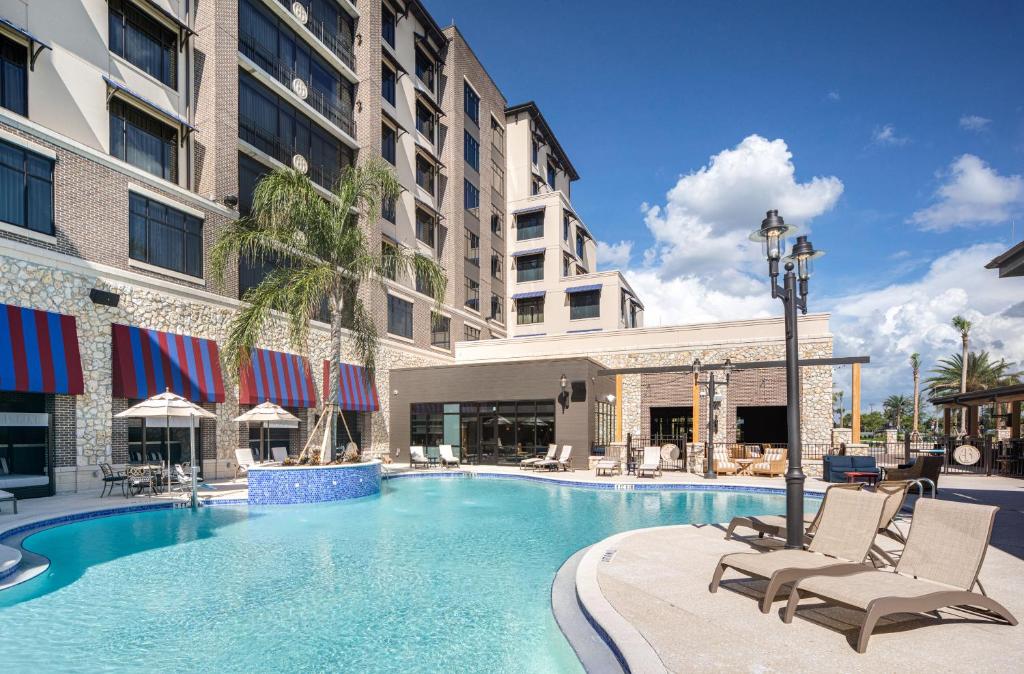 a swimming pool at a hotel with chairs and a building at The Brownwood Hotel & Spa in The Villages