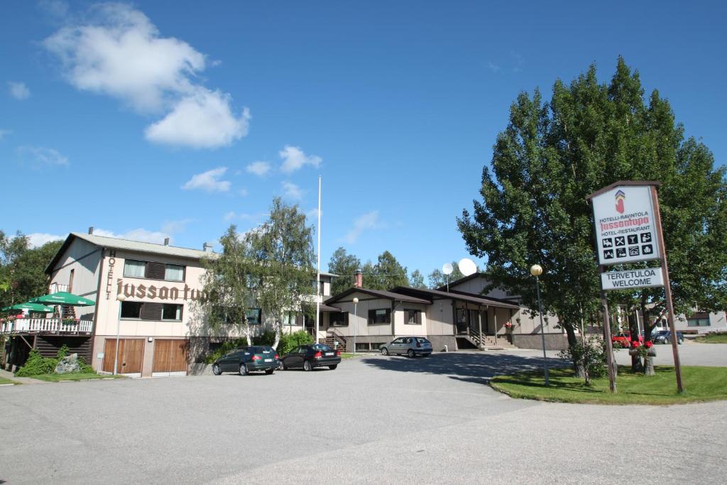 un estacionamiento con un cartel frente a un edificio en Hotelli Jussan Tupa, en Enontekiö