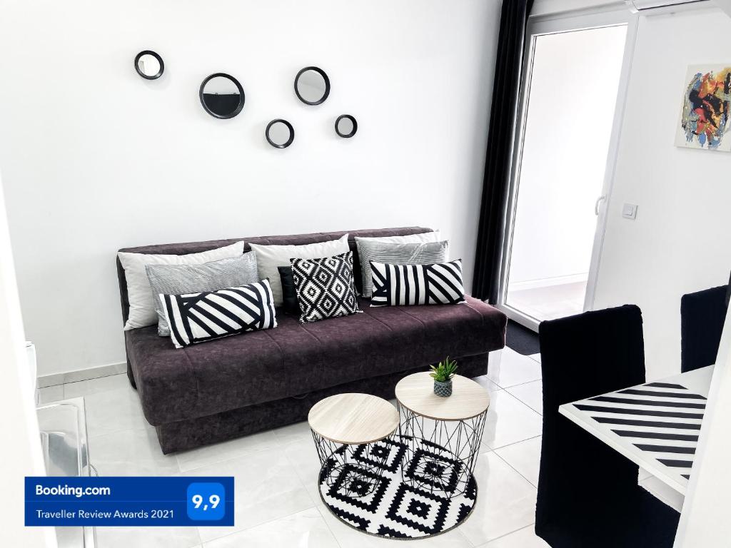 ein Wohnzimmer mit einem Sofa mit Kissen darauf in der Unterkunft Apartments Monako in Herceg-Novi