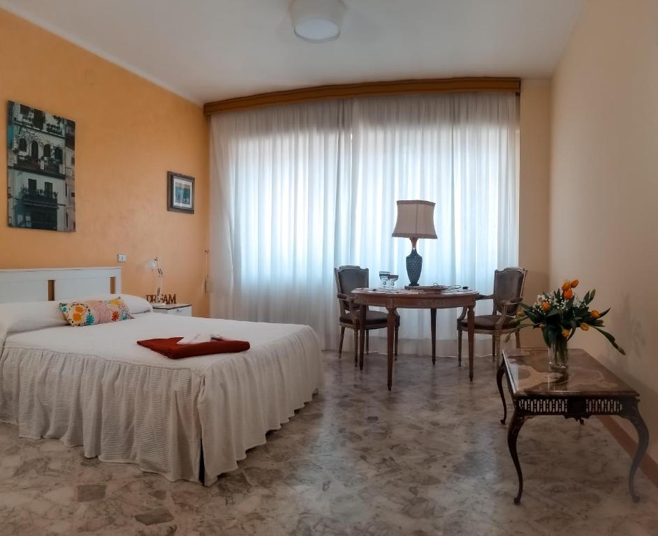 a bedroom with a bed and a table and chairs at Via Sparano Suite in Bari