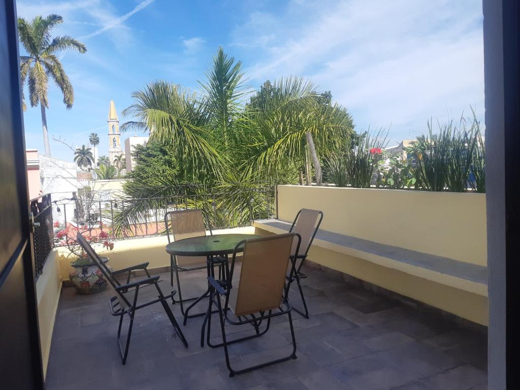 a patio with a table and chairs on a balcony at Aguacate Suites in Mazatlán