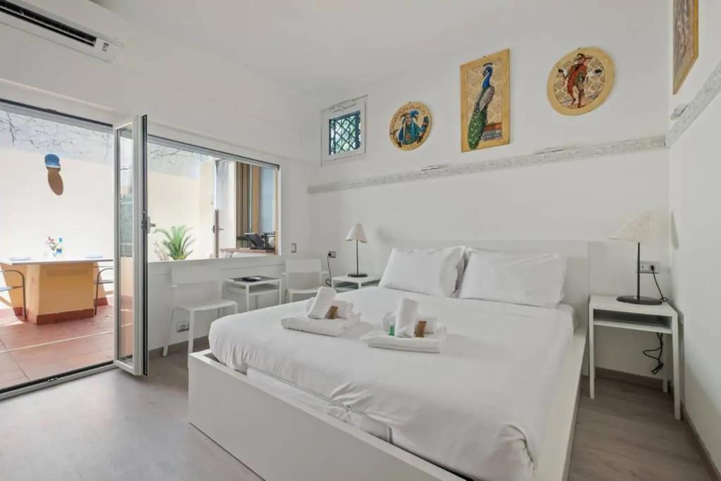 ein weißes Schlafzimmer mit einem großen weißen Bett und einem Schreibtisch in der Unterkunft HostMe flat Metro Spagna in Rom