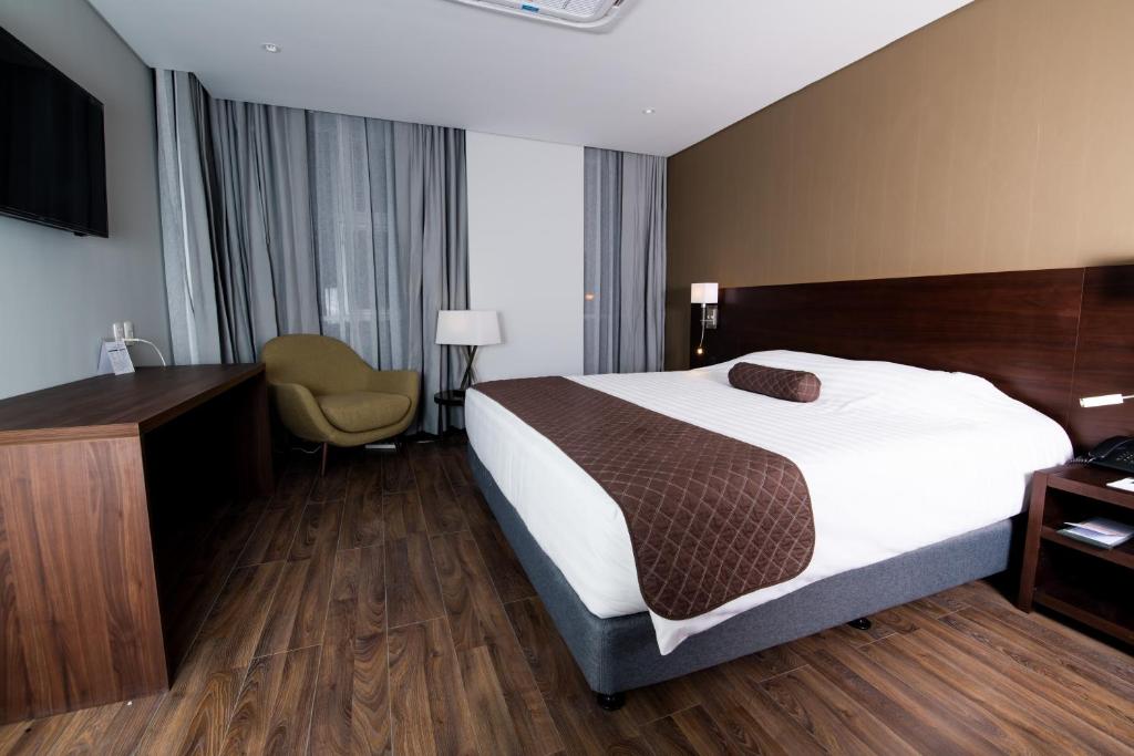 拉巴斯的住宿－雷諾瓦酒店，配有一张床和一张书桌的酒店客房