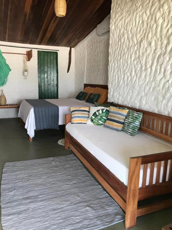 a room with two beds and a couch in it at Pousada Yemanjá Toré in Barra de Camaratuba