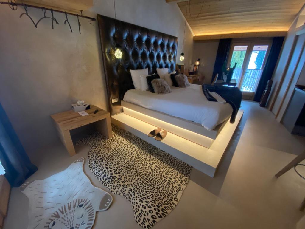 Schlafzimmer mit einem großen Bett mit einem schwarzen Kopfteil in der Unterkunft Lodge Jardin Secret - Propriétés Mont Amour in Montriond