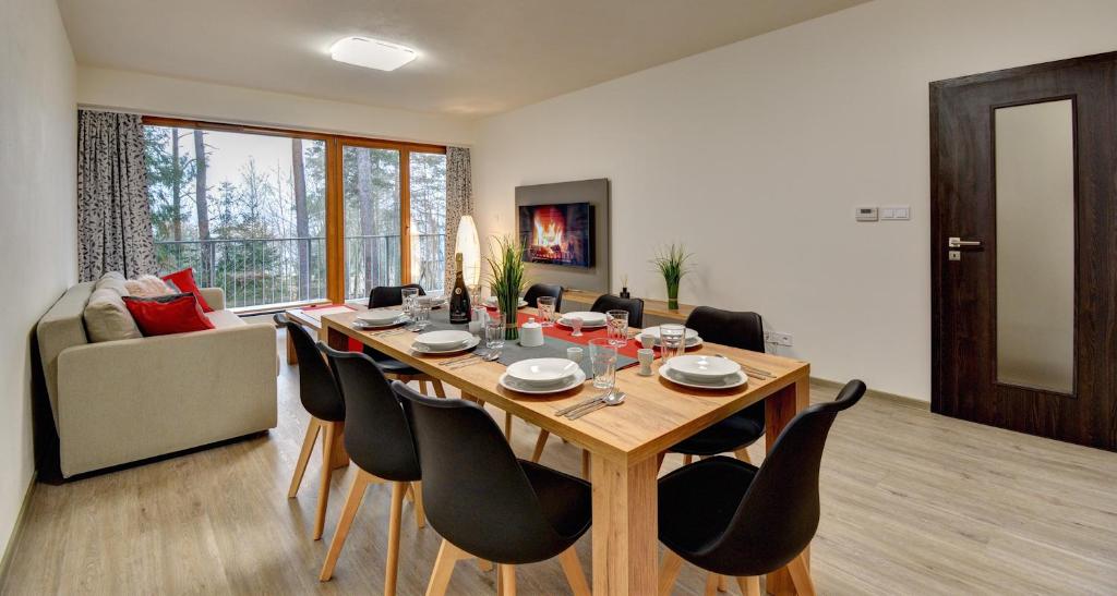 uma mesa de jantar e cadeiras numa sala de estar em Apartmány Sunny Lipno em Lipno nad Vltavou