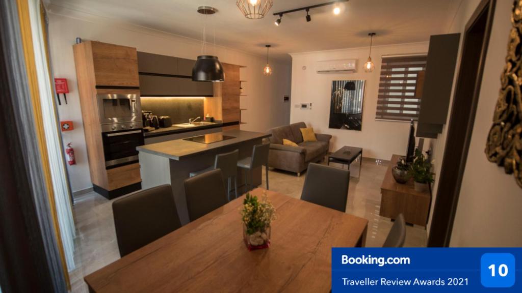 a kitchen and living room with a table and a couch at Msiebah Court San Gwann Modern Apt near Sliema and St Julians in San Ġwann