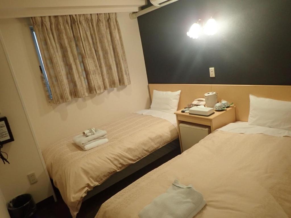 twee bedden in een hotelkamer met handdoeken erop bij Hotel Suntargas Ueno - Vacation STAY 08481v in Tokyo