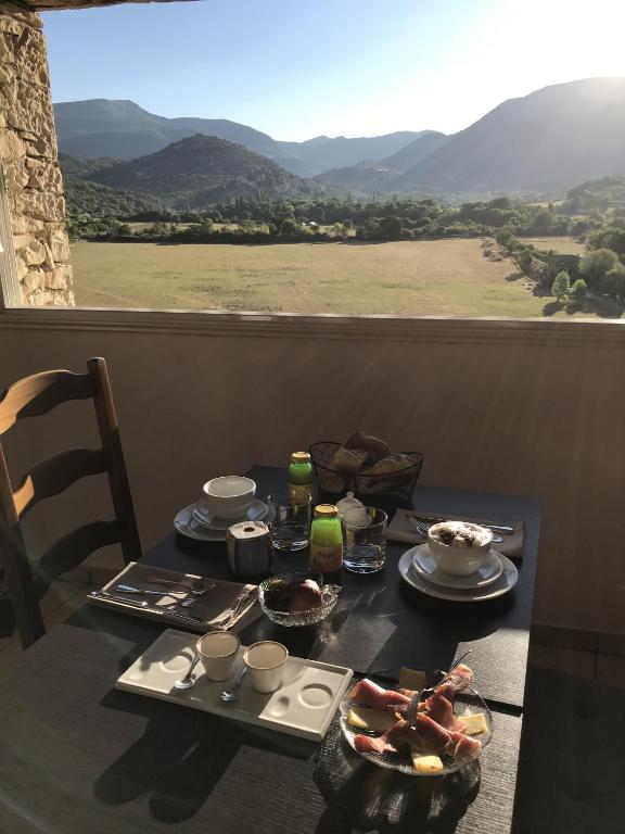 - une table avec de la nourriture et une vue sur les montagnes dans l&#39;établissement Hotel L&#39;Oustau de la Font, à Reilhanette