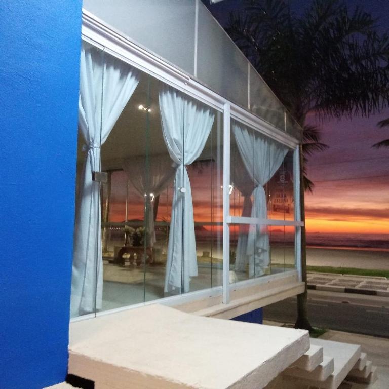 un edificio con ventanas con puesta de sol en el fondo en Asturias Mall & Suítes, en Guarujá