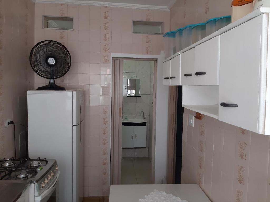 a small kitchen with a refrigerator and a stove at Aparkit Vila Caiçara in Solemar