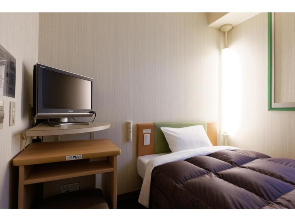 um quarto com uma cama e uma televisão numa mesa em R&B Hotel Hakata Ekimae 1 - Vacation STAY 16386v em Fukuoka