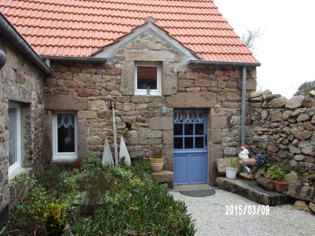 a stone house with a blue door at LA VUULE MAISON in Fermanville