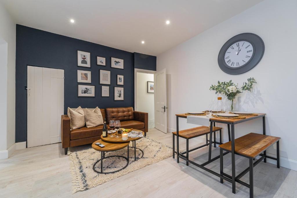 a living room with a couch and a clock on the wall at South View - 3 bed modern Chester house - Close to city centre in Chester