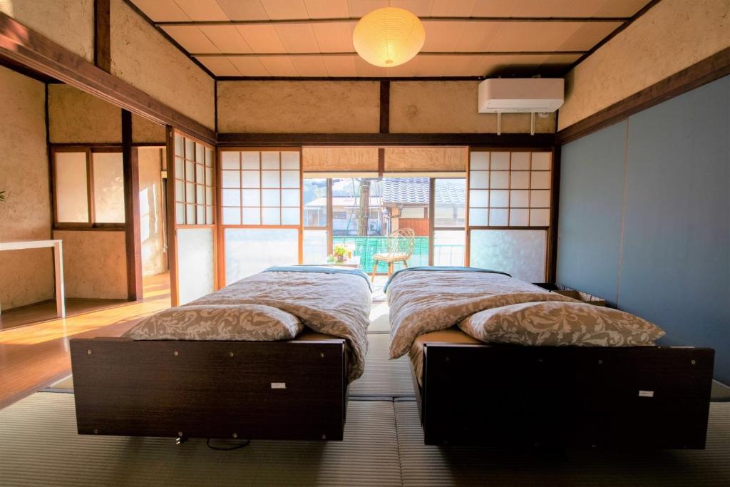 een slaapkamer met 2 bedden en een groot raam bij Oto Iro Riva HOUSE - Vacation STAY 18694v in Kure