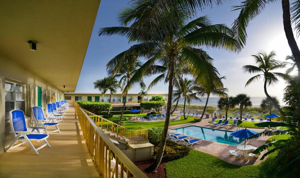 balcón del complejo con sillas, piscina y palmeras en Tropic Seas Resort, en Fort Lauderdale