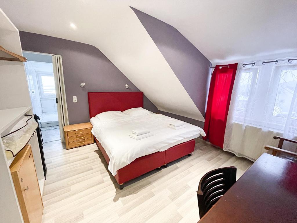 a bedroom with a bed with a red headboard at Glashütten Hotel in Glashütten