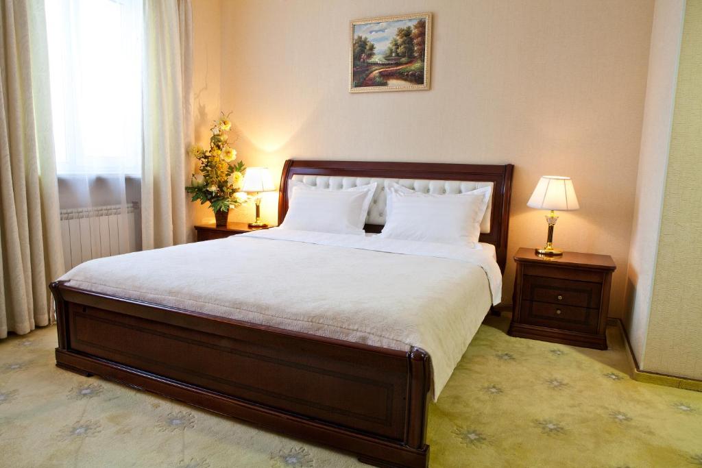 a bedroom with a large bed with white sheets and pillows at Richmond Hotel in Yekaterinburg