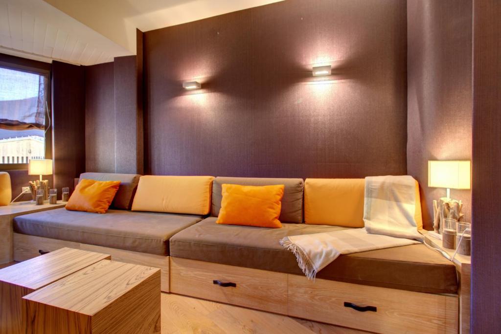 un sofá con almohadas naranjas en una habitación en Camarote by Totiaran, en Baqueira Beret