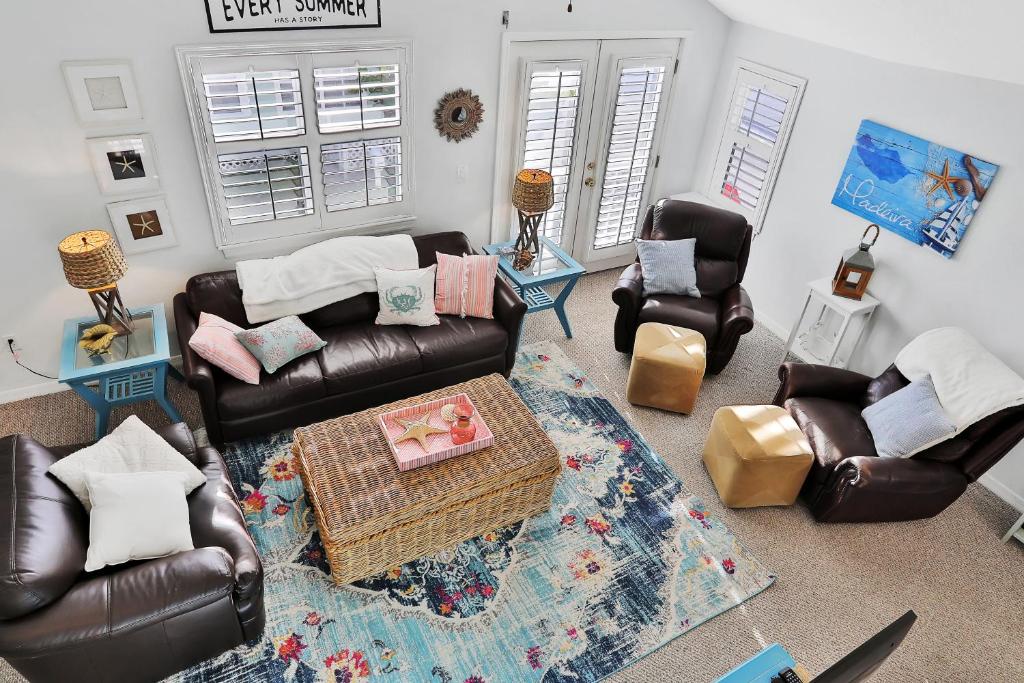 a living room with two leather chairs and a table at Sol Mate Beach Cottage in St Pete Beach