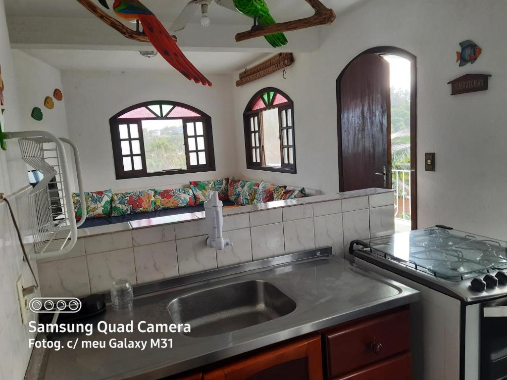 a kitchen with a sink and a counter top at Chalés Monções in Ubatuba