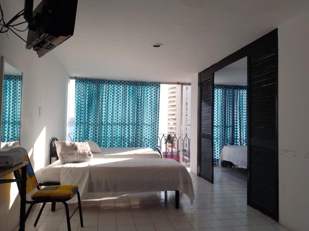 a bedroom with a bed and a large window at Hotel Condesa Americana Acapulco in Acapulco