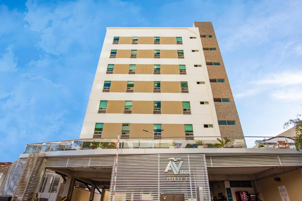 un edificio blanco alto con un letrero. en Hotel Ave Inn en Mazatlán