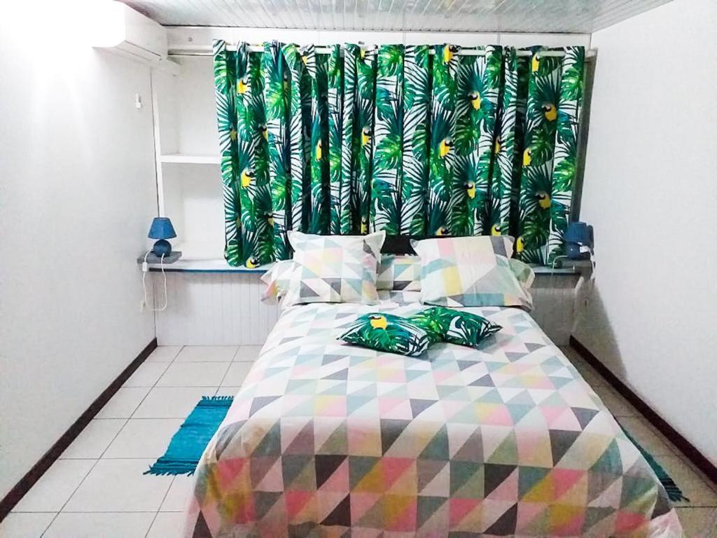 a bedroom with a bed with a colorful bedspread at bas de VILLA LARCHER avec piscine in Le Marin