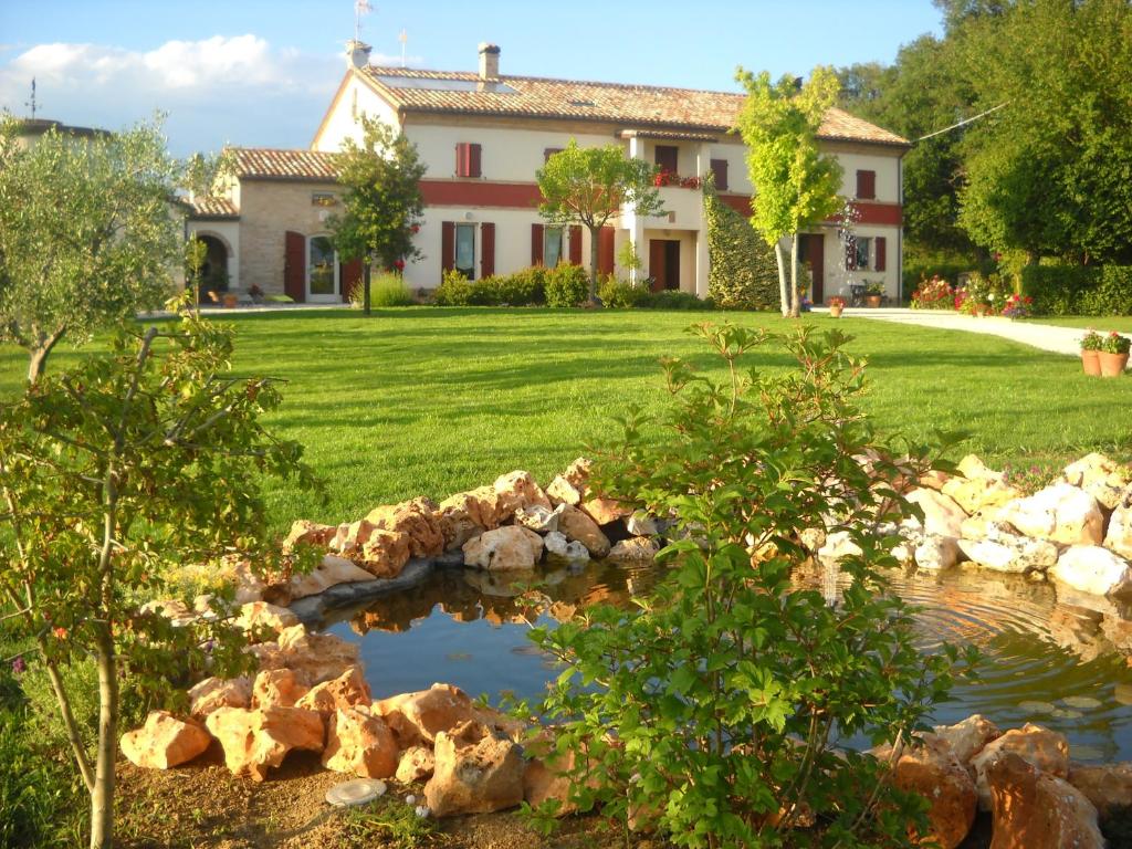 una casa con un estanque frente a un patio en B&B Campodisole, en Osimo