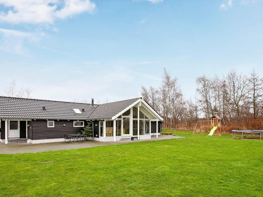 a house with a large yard with a playground at Holiday home Idestrup III in Marielyst