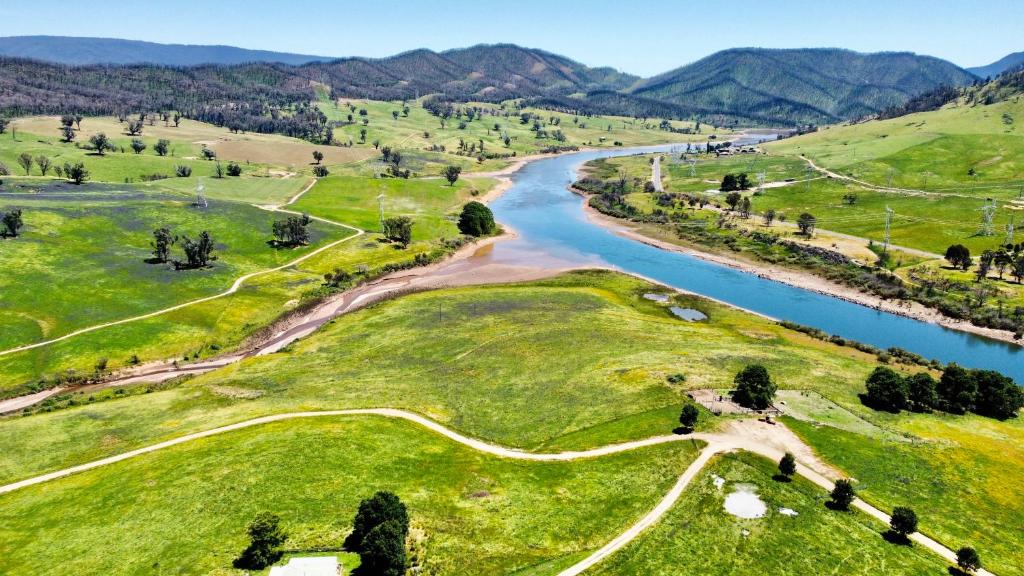 an aerial view of a river and green fields at Pether Cottage - Talbingo NSW in Talbingo