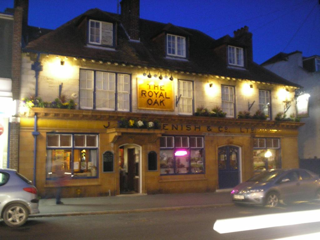 um edifício numa rua com carros estacionados em frente em The Royal Oak em Weymouth