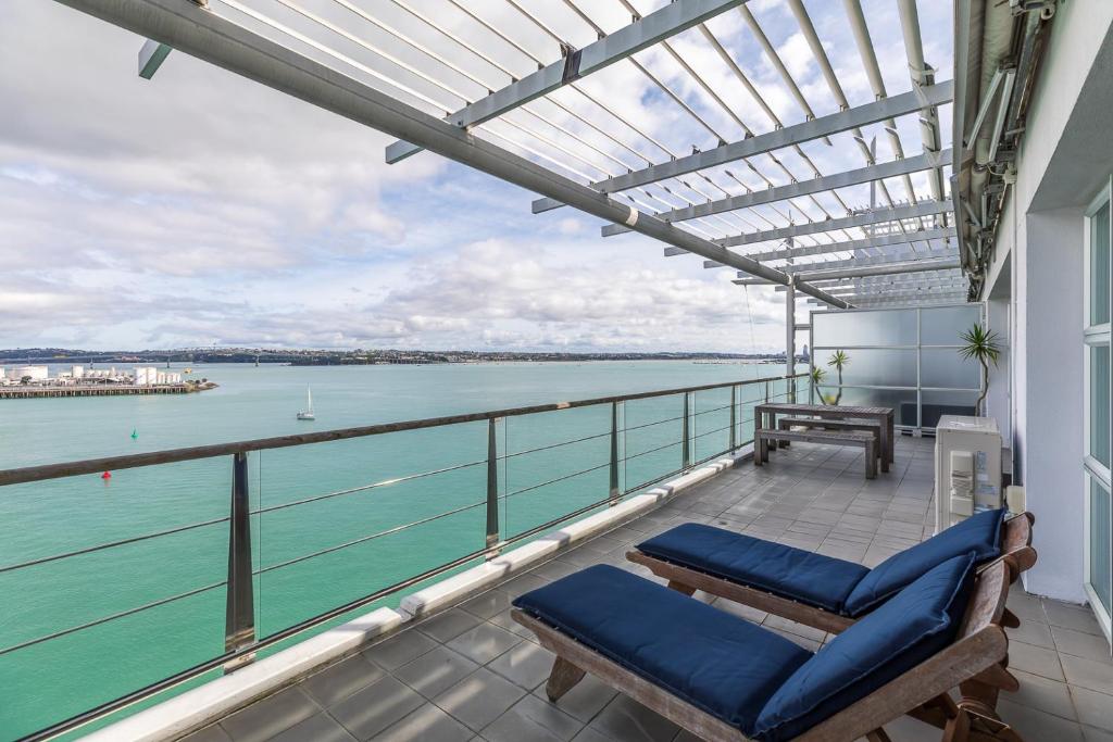 a balcony with chairs and a view of the water at QV Waterfront Apt with AC Wifi and Parking (941) in Auckland