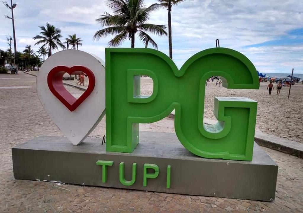 un cartello verde e un cuore sulla spiaggia di Apartamento Praia Grande- SP Vila Tupi a Praia Grande