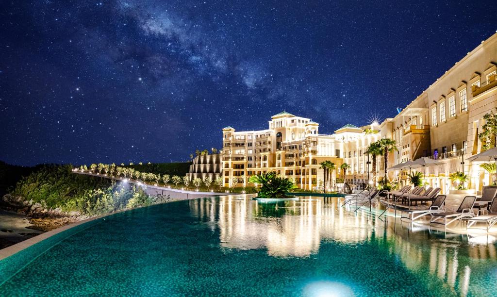 a hotel with a swimming pool at night at Sol Beach Jindo in Jindo