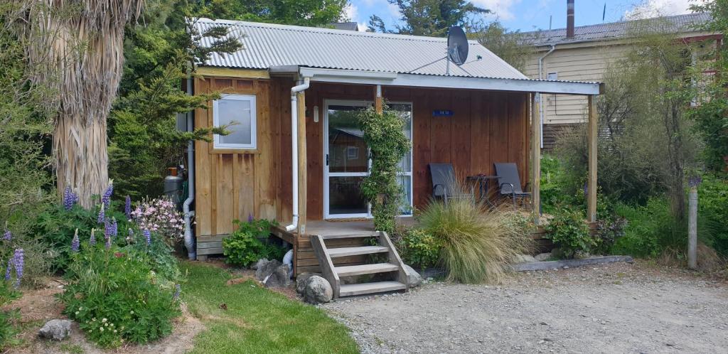 una piccola casa con una scala in un cortile di Lake Tekapo Cottages a Lake Tekapo