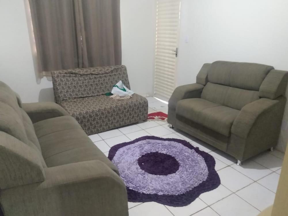 a living room with two chairs and a purple rug at Comfortable Home in Valparaíso de Goiás