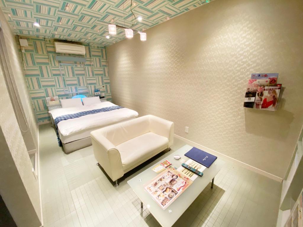 Un dormitorio con una cama, un sofá y una mesa. en CURE, en Sumino