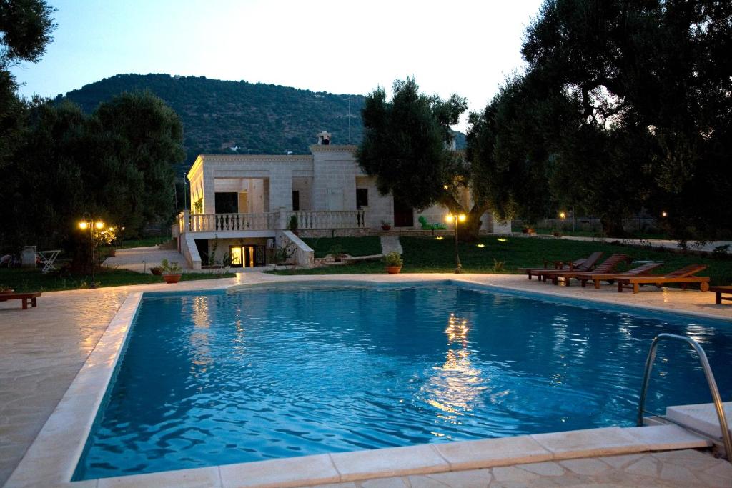 une grande piscine en face d'une maison dans l'établissement La Vigna Vecchia, à Fasano