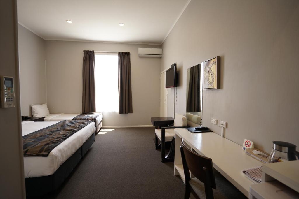 Pokój hotelowy z 2 łóżkami i biurkiem w obiekcie Alpers Lodge & Conference Centre w Auckland