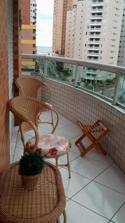 uma varanda com 2 cadeiras e uma mesa em Apartamento praia Grande em São Paulo