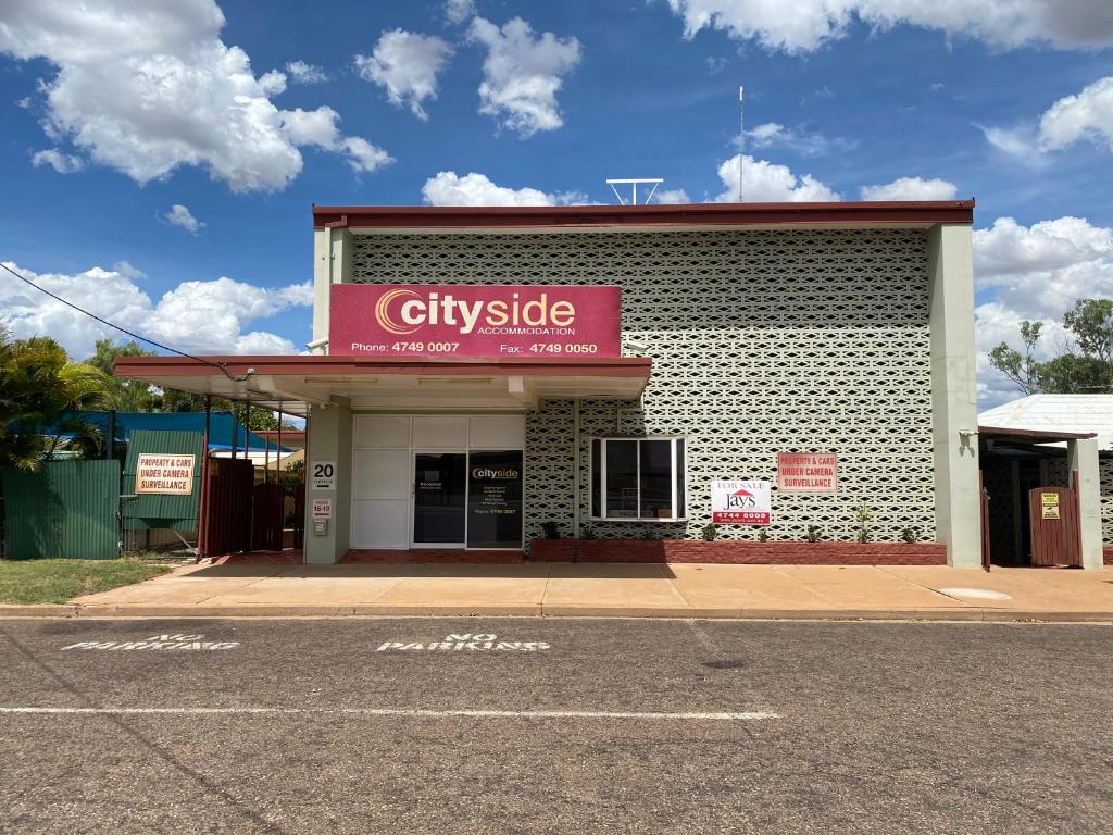 a building with a red sign on the side of it at Cityside Accommodation in Mount Isa
