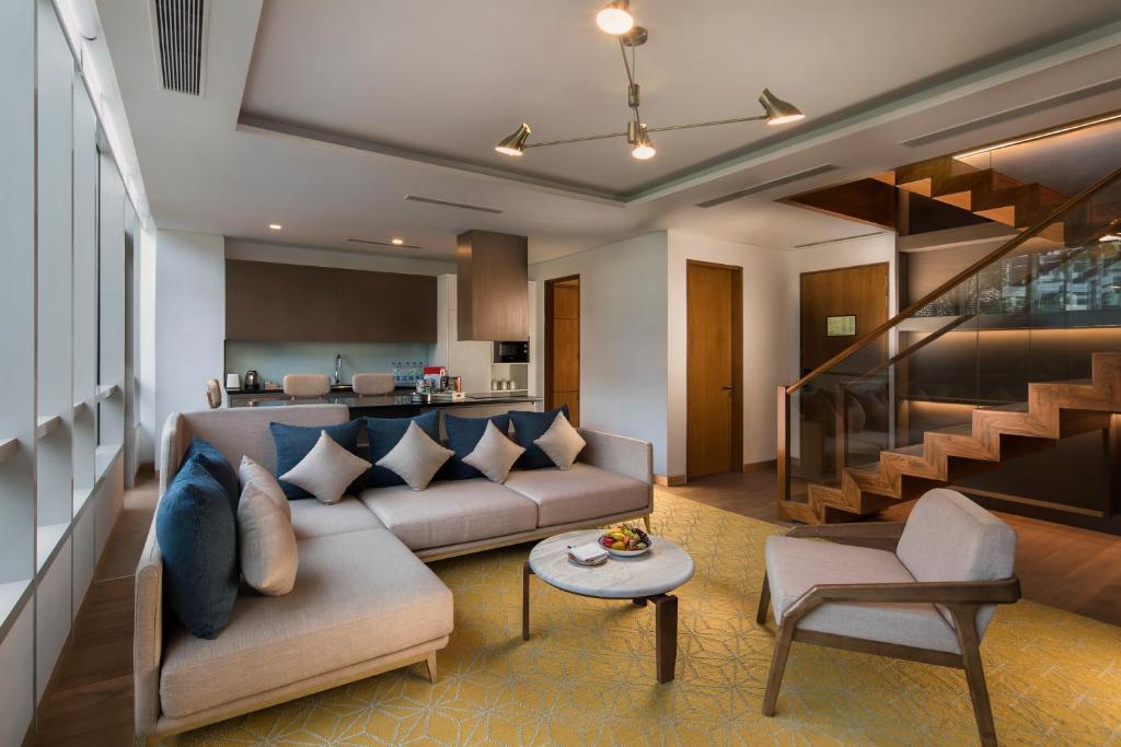 a living room with a couch and a staircase at Hyatt Delhi Residences in New Delhi