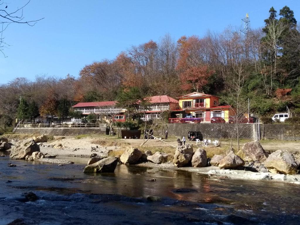 ein Haus am Ufer eines Flusses in der Unterkunft Akiu Canada 鴻の巣温泉 in Sendai