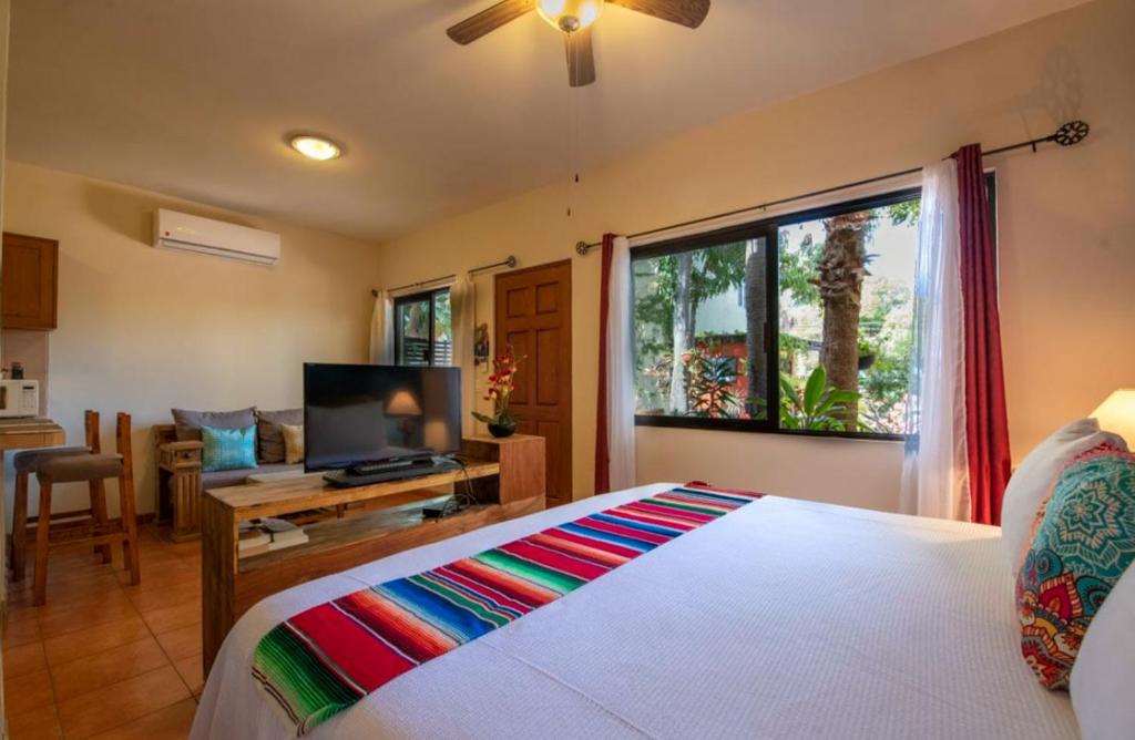 um quarto com uma cama, uma televisão e uma janela em Hotel Casa Mangos Loreto em Loreto