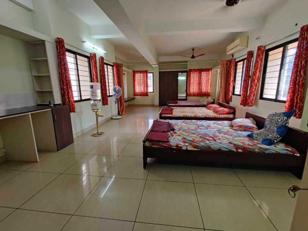 a large room with two beds and a kitchen at RAK RESIDENCY in Tiruchirappalli