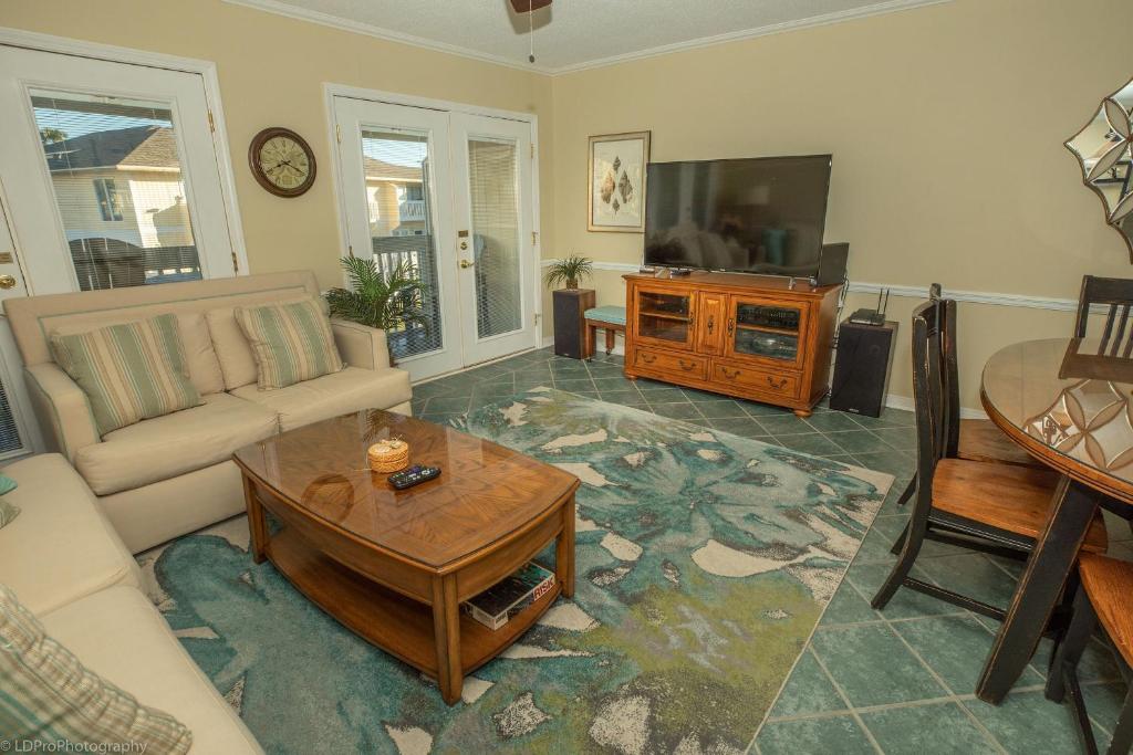 een woonkamer met een bank, een tafel en een tv bij Sandpiper Cove 4216 Destin Condo in Destin