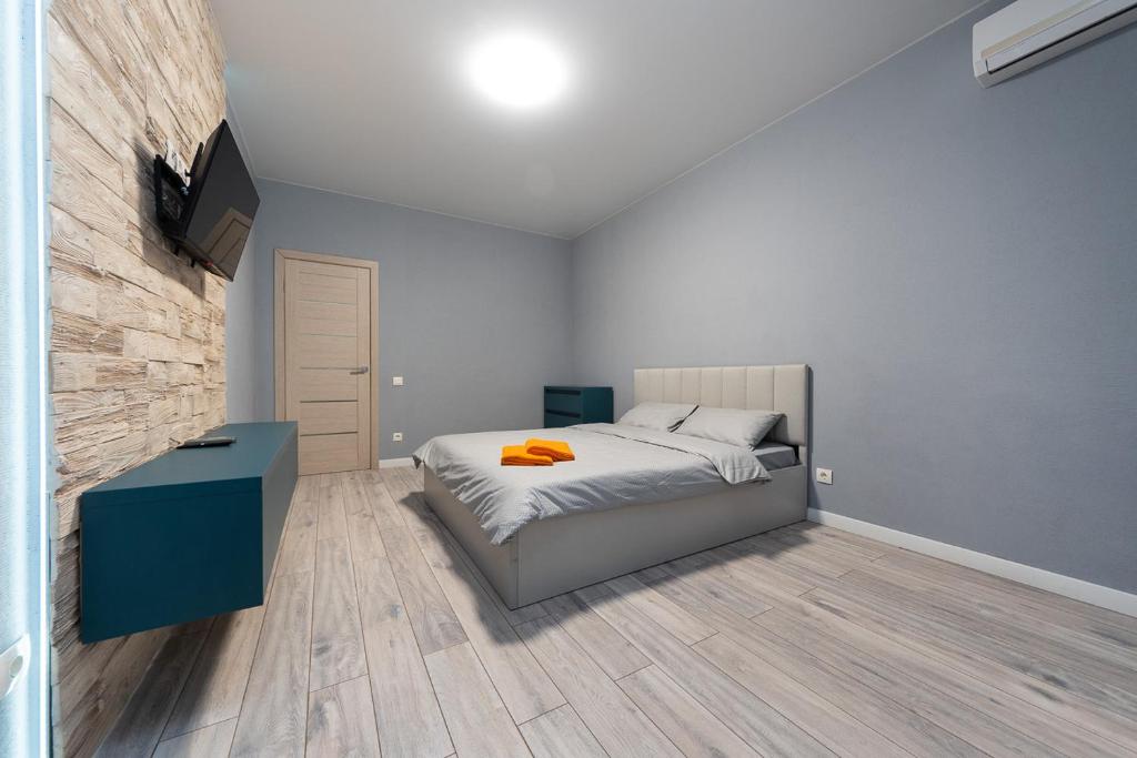 1 dormitorio con 1 cama y TV en la pared en ЖК Парк Ленд метро Васильковская Люкс, en Kiev