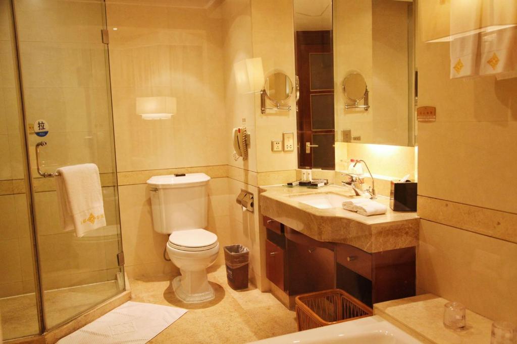 a bathroom with a toilet and a sink and a shower at Yidu Jinling Grand Hotel Yancheng in Yancheng