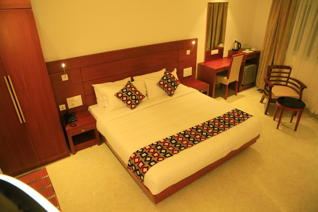 een slaapkamer met een groot bed in een hotelkamer bij Hotel Victoria International in Kattappana